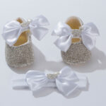 Χειροποίητο σετ παπουτσάκια αγκαλιάς με κορδέλα: Λευκός φιόγκος και ασημί στρας "Καρδιά με κορώνα"